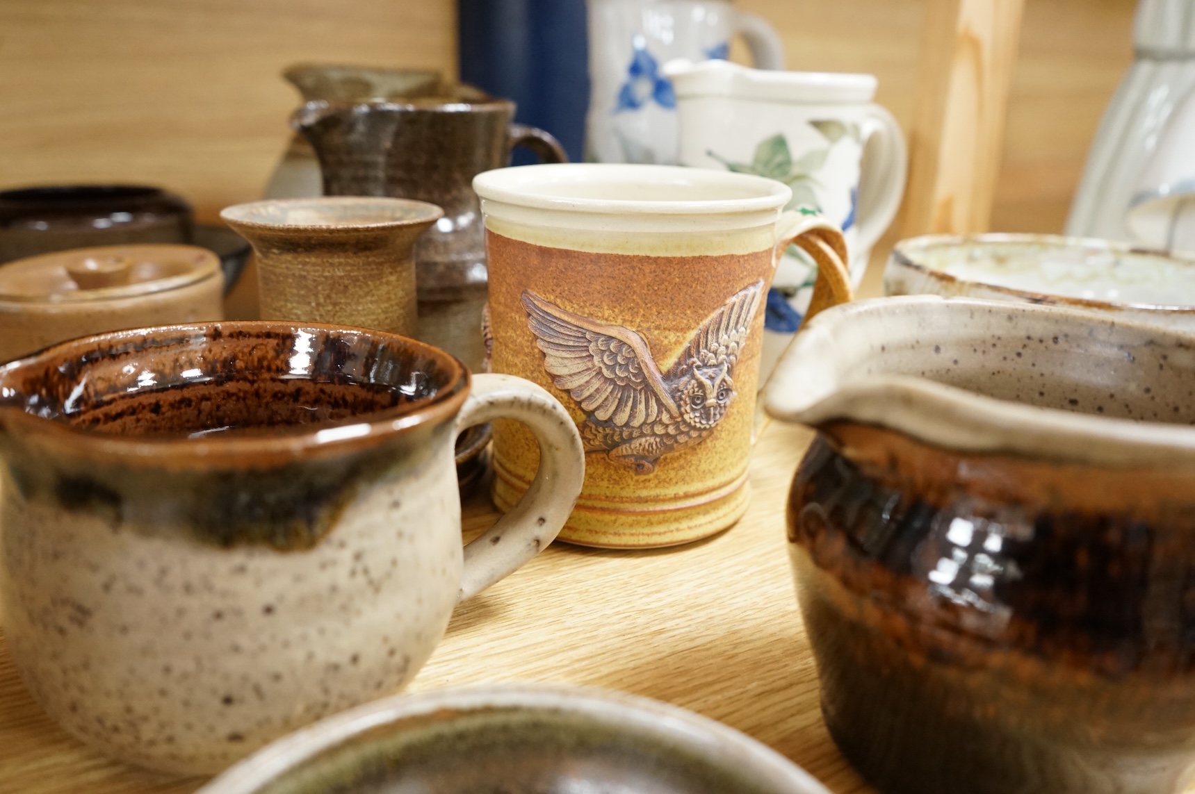A large collection of studio pottery mugs bowls and jugs, tallest jug 21cm.